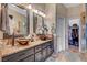 Bathroom featuring dual vessel sinks with granite countertops and walk-in closet at 6105 Port Of Dreams Dr, Las Vegas, NV 89130