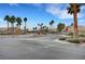 Community entrance featuring palm trees, lush landscaping, and controlled access at 6105 Port Of Dreams Dr, Las Vegas, NV 89130