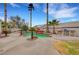 Relaxing pool area with lush landscaping, a rock waterfall feature, tall palm trees, and outdoor kitchen area at 6105 Port Of Dreams Dr, Las Vegas, NV 89130