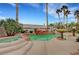 Private backyard oasis featuring a rock-rimmed pool, spa, lush landscaping, and towering palm trees at 6105 Port Of Dreams Dr, Las Vegas, NV 89130