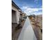 Long walkway along homes with desert landscaping and distant hillside views at 6154 Rathbone St, Las Vegas, NV 89166