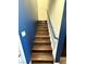 A staircase with dark wood steps and a blue accent wall is well lit at 6154 Rathbone St, Las Vegas, NV 89166