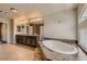 Bathroom features a large tub with marble detail, dual sinks, and a large window for natural light at 6250 Sierra Knolls Ct, Las Vegas, NV 89139