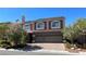 Two-story home showcasing a three-car garage and beautiful brick accents at 6250 Sierra Knolls Ct, Las Vegas, NV 89139