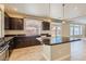 Open kitchen with an island, dark cabinetry, and tile flooring at 6250 Sierra Knolls Ct, Las Vegas, NV 89139