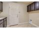 A neutral laundry room with tile flooring, dark cabinets and a utility sink at 6250 Sierra Knolls Ct, Las Vegas, NV 89139