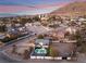 Aerial view of a modern home with a pool and stunning mountain views at sunset at 6885 Stone Dr, Las Vegas, NV 89110