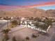 Aerial view showcasing a modern home's exterior, pool, and mountain backdrop at sunset at 6885 Stone Dr, Las Vegas, NV 89110