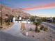 Sunset aerial view of a modern home with a two-car garage and driveway at 6885 Stone Dr, Las Vegas, NV 89110