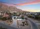 Aerial view of a remodeled home with mountain views at sunset at 6885 Stone Dr, Las Vegas, NV 89110