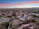 Aerial view showing a home's modern design, pool, and expansive city views at sunset at 6885 Stone Dr, Las Vegas, NV 89110