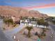 Modern two-story house with attached garage, viewed from above.Landscaped lot with mature palm trees at 6885 Stone Dr, Las Vegas, NV 89110