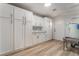 Laundry room with white cabinets, a utility sink, and light wood floors at 6885 Stone Dr, Las Vegas, NV 89110