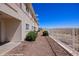 Backyard view featuring rock landscaping, shrubs, sturdy metal fence, and the exterior of the home at 700 Aztec Cir # 2E, Mesquite, NV 89027