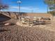 Cozy backyard seating area with a stone fire pit and gravel landscaping, ideal for evening gatherings at 7076 Oakleigh Dr, Las Vegas, NV 89110