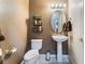 Half bath with decorative shelving, oval mirror, pedestal sink, and white toilet at 7076 Oakleigh Dr, Las Vegas, NV 89110