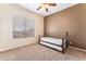 Neutral bedroom features a ceiling fan and a bed with carpeted floors at 7076 Oakleigh Dr, Las Vegas, NV 89110