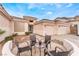 Inviting patio with seating, leading to a single-story home with a three-car garage and desert landscaping at 7076 Oakleigh Dr, Las Vegas, NV 89110