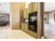 Kitchen area with black oven, matching countertops and backsplash, and beige tile flooring at 7076 Oakleigh Dr, Las Vegas, NV 89110