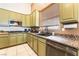 Well-lit kitchen features granite countertops, stainless steel appliances, and light green cabinets at 7076 Oakleigh Dr, Las Vegas, NV 89110