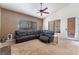 Inviting living room featuring a plush leather sectional, ceiling fan, and natural light at 7076 Oakleigh Dr, Las Vegas, NV 89110