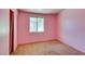 Bedroom with pink painted walls, carpet flooring and a window with security bars at 709 N 22Nd St, Las Vegas, NV 89101