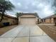 Beige one story home featuring a two car garage and neutral desert landscaping at 7949 Long Beach St, Las Vegas, NV 89139