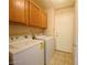 Bright laundry room with washer and dryer, neutral tile, and ample upper cabinet space at 7949 Long Beach St, Las Vegas, NV 89139