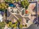 Aerial view of a house with a pool, tile roof, solar panels, mature trees, and desert landscaping at 8875 Steven Chase Ct, Las Vegas, NV 89149