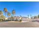 Single-story home with a circular driveway, a two-car garage, manicured landscaping, and many palm trees at 8875 Steven Chase Ct, Las Vegas, NV 89149