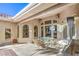 A spacious covered patio features an outdoor kitchen, glass-top table, and backyard views with exterior speakers at 8875 Steven Chase Ct, Las Vegas, NV 89149