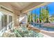 Covered patio featuring an outdoor kitchen, a glass topped table with seating, and a view of the refreshing backyard pool at 8875 Steven Chase Ct, Las Vegas, NV 89149