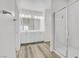 Modern bathroom with a double sink vanity, wood-look floors, and walk-in glass shower at 92 Starlight Sonata Ave, Henderson, NV 89015