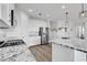 Modern kitchen with white cabinetry, granite countertops, stainless steel appliances, and wood-style flooring at 92 Starlight Sonata Ave, Henderson, NV 89015