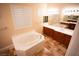 Spa-like bathroom with a large soaking tub and double sinks at 9408 Forest Edge Ave, Las Vegas, NV 89149