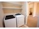 Bright laundry room with washer, dryer, and extra shelving at 9408 Forest Edge Ave, Las Vegas, NV 89149