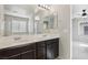 Double vanity bathroom with dark brown cabinets and large mirror at 9875 Vista Meadows Ave, Las Vegas, NV 89148