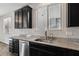 Kitchen features dark cabinetry, granite countertops, and stainless steel sink at 9875 Vista Meadows Ave, Las Vegas, NV 89148