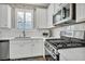 White kitchen with stainless steel appliances and tiled backsplash at 10211 Starlit Canyon Ct, Las Vegas, NV 89141