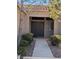 Inviting front entrance with decorative security door, tiled foyer and charming desert landscaping at 10709 Hunters Woods Pl, Las Vegas, NV 89134