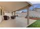 Spacious covered patio with cozy seating area that overlooks the pool and garden at 1073 Silver Bullet Ct, Henderson, NV 89011