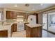 Modern kitchen featuring granite countertops, wood cabinets, white appliances, and tile flooring at 1073 Silver Bullet Ct, Henderson, NV 89011