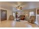 Warm living room with tile flooring, comfortable seating, ceiling fan, and neutral paint colors at 1073 Silver Bullet Ct, Henderson, NV 89011