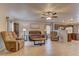 Cozy living room with tile floors, comfortable seating, a ceiling fan, and open access to the kitchen at 1073 Silver Bullet Ct, Henderson, NV 89011