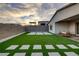 Artificial turf backyard with stone patio and seating area at 11671 Hatchling Ave, Las Vegas, NV 89138