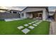 Artificial turf backyard with stone patio and seating area at 11671 Hatchling Ave, Las Vegas, NV 89138