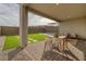 Covered patio with artificial turf, stone pavers, and seating area at 11671 Hatchling Ave, Las Vegas, NV 89138