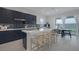 Modern kitchen with island, stainless steel appliances, and dark cabinetry at 11671 Hatchling Ave, Las Vegas, NV 89138