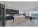 Modern kitchen with island, stainless steel appliances, and dark cabinetry at 11671 Hatchling Ave, Las Vegas, NV 89138