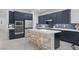 Modern kitchen with dark cabinetry and white island at 11671 Hatchling Ave, Las Vegas, NV 89138